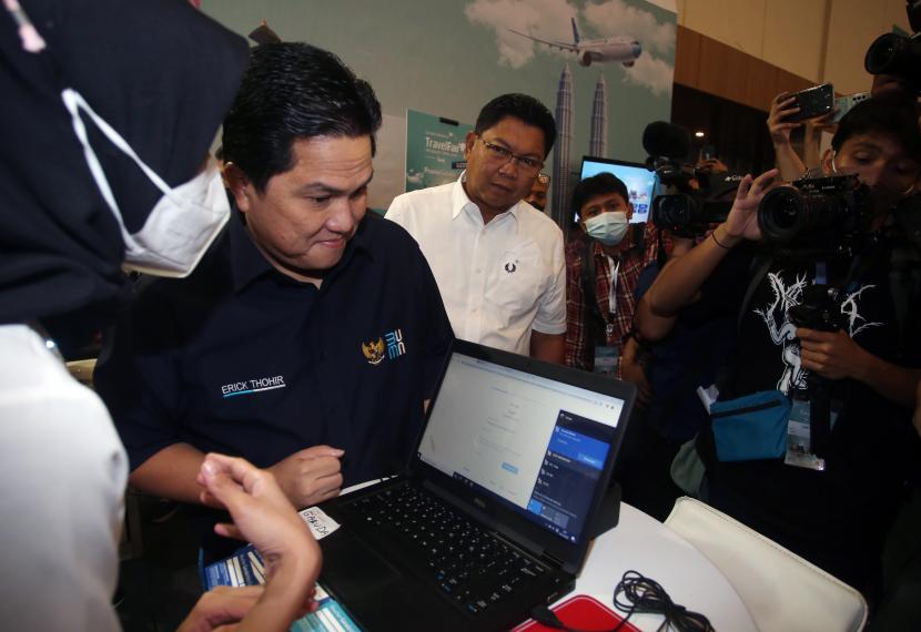 Menteri BUMN Erick Thohir (kedua kiri) bersama Dirut Bank Mandiri Darmawan Junaidi (ketiga kiri) melihat transaksi penjualan agen perjalanan saat meninjau ruang pameran usai membuka perhelatan Garuda Indonesia Travel Fair (GATF) 2022 yang didukung oleh Livin