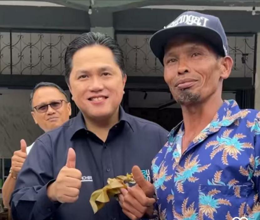 Menteri BUMN Erick Thohir menikmati makanan khas ombus-ombus yang dibeli dari pedagang jalanan di Tarutung, Sumatra Utara. 