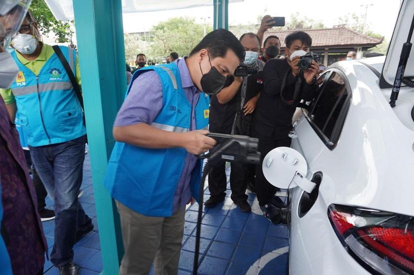 Menteri BUMN Erick Thohir sedang mengisi daya kendaraan listrik di stasiun pengisian mobil listrik (charging station) di Denpasar, Bali, Sabtu (2/1). Pemerintah akan menaikkan tarif pajak penjualan atas barang mewah (PPnBM) menjadi 14 persen bagi kendaraan mobil listrik.