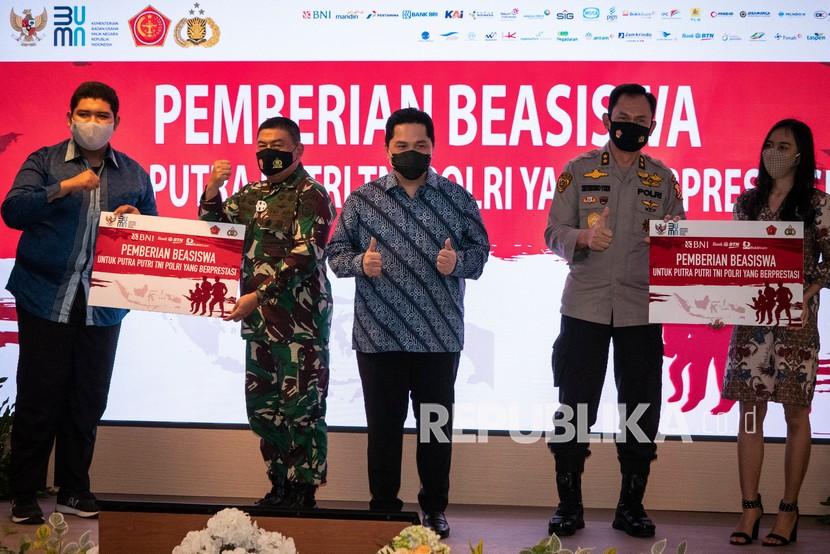 Menteri BUMN Erick Thohir (tengah) bersama Aster Panglima TNI Mayjen TNI Madsuni (kedua kiri) dan Asisten Kapolri Bidang Sumber Daya Manusia Irjen Pol Sutrisno Yudi Hermawan (kedua kanan) menyerahkan secara simbolis Beasiswa kepada perwakilan Putra Putri TNI Polri yang Berprestasi di Kementerian BUMN, Jakarta, Selasa (10/11/2020). BNI dan 33 BUMN lainnya memberikan bantuan dana pendidikan kepada 2.200 putra dan putri prajurit TNI dan anggota Polri yang berprestasi dari 34 provinsi di Indonesia. 