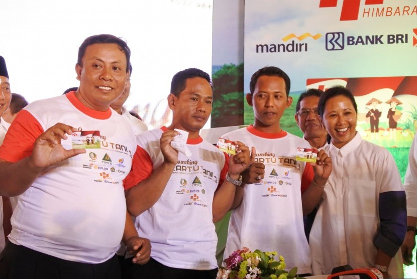 Menteri BUMN Rini Soemarno (kanan) bersama petani memperlihatkan kartu tani di Pabrik Gula (PG) Asembagus, Situbondo, Jawa Timur, Rabu (16/11). 