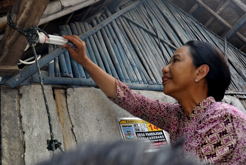 Menteri BUMN Rini Soemarno memasang lampu LED saat meninjau pemasangan listrik gratis untuk keluarga tidak mampu di Carenang, Serang, Banten, Jumat (13/7). 