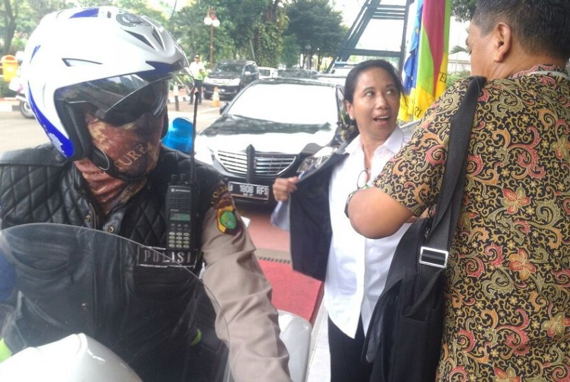 Menteri BUMN Rini Soemarno (tengah) melepas jaket usai diantar dengan sepeda motor patwal ketika menuju Kantor Menko Perekonomian, Jumat (4/11).