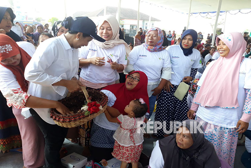 Menteri BUMN Rini Sumarno, diserbu petani dan warga Desa Lemah Duhur, Kecamatan Tempuran, Karawang, saat membagikan telor asin batik, Kamis (19/4). 