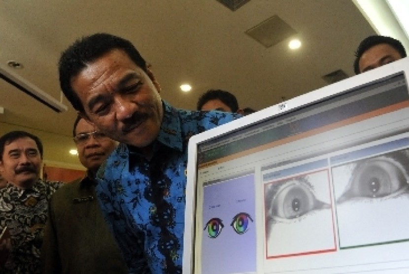 Menteri Dalam Negeri Gamawan Fauzi mengecek data e-KTP miliknya dengan sistem pemindaian iris mata di Kementerian Dalam Negeri, Jakarta Pusat.