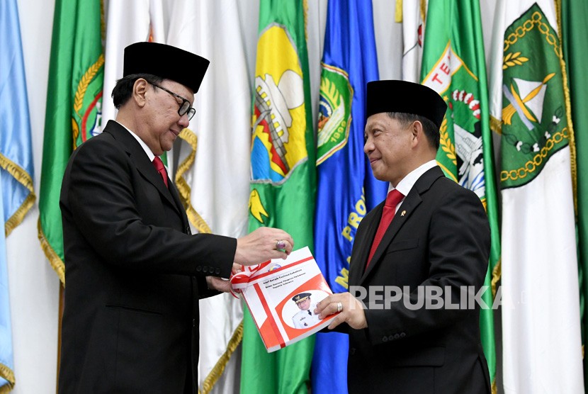 Menteri Dalam Negeri Tito Karnavian (kanan) menerima memori serah terima jabatan dari pejabat lama Tjahjo Kumolo (kiri) saat serah terima jabatan di Kantor Kemendagri, Jakarta, Rabu (23/10/2019). 