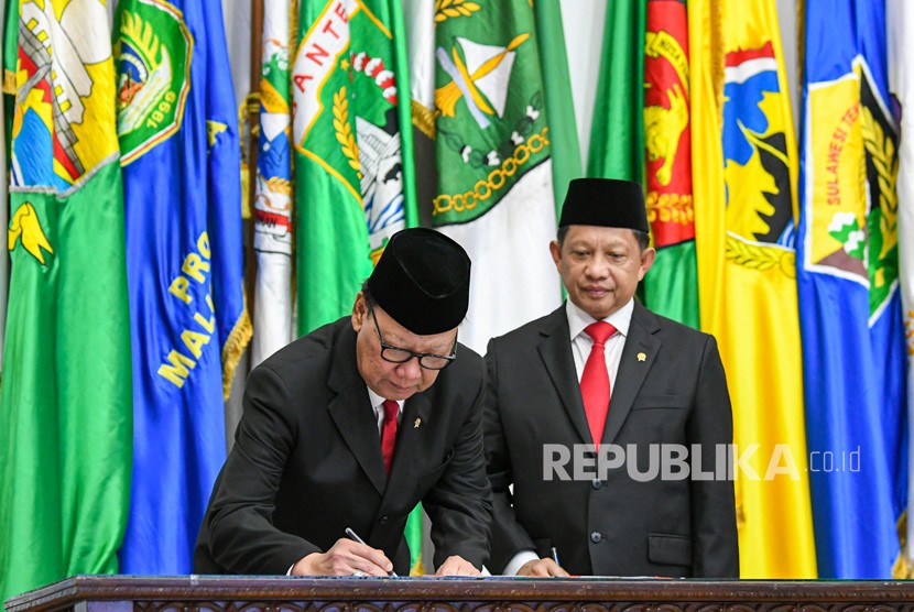 Menteri Dalam Negeri Tito Karnavian (kanan) menyaksikan pejabat lama Tjahjo Kumolo (kiri) menandatangani berita acara serah terima jabatan di Kantor Kemendagri, Jakarta, Rabu (23/10/2019). 