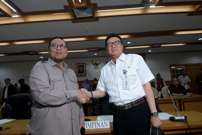 Menteri Dalam Negeri Tjahjo Kumolo (kanan) bersalaman dengan Ketua Pansus RUU Pemilu Lukman Edy (kiri) sebelum memulai rapat di Kompleks Parlemen, Senayan, Jakarta, Rabu (14/6).