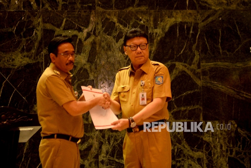 Menteri Dalam Negeri Tjahjo Kumolo memberikan Surat Keputusan Pelaksana Tugas (Plt) Gubernur DKI Jakarta kepada Wakil Gubernur DKI Jakarta Djarot Syaiful Hidayat di Balai Agung, Balaikota, Jakarta, Selasa (9/5).