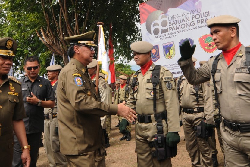 Menteri Dalam Negeri Tjahjo Kumolo (tengah) menyalami sejumlah personel Satpol PP usai upacara hari ulang tahun (HUT) Satuan Polisi Pamong Praja (Satpol PP) dan Perlindungan Masyarakat (Linmas) di Palu, Sulawesi Tengah, Kamis (3/3).