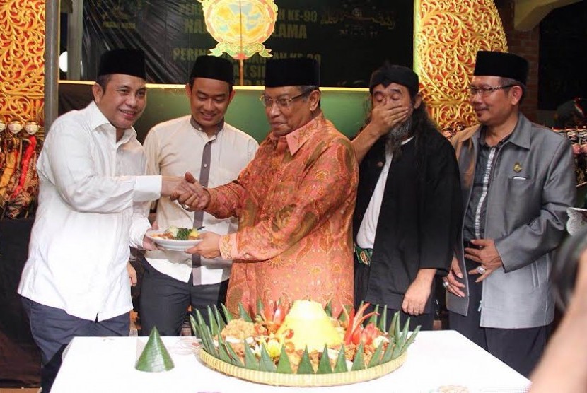 Menteri Desa, Pembangunan Daerah Tertinggal dan Transmigrasi, Marwan Jafar, menerima nasi tumpeng dari Ketua Umum PBNU, KH Said Aqil Siradj, dalam acara Harlah NU ke-90, di Jakarta, Sabtu malam (31/1)