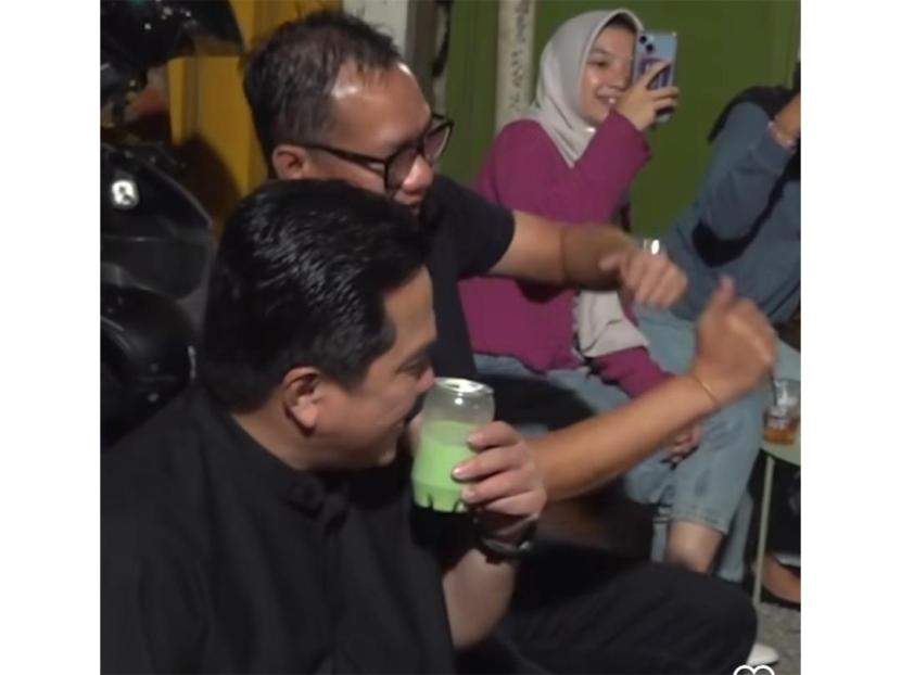 Menteri Erick Thohir ketika nongkrong bareng musisi jalanan di Surabaya sambik menyeruput minuman lokal.