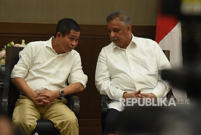 Menteri ESDM Ignasius Jonan (kiri) berbincang dengan Direktur Utama PT PLN (Persero) Sofyan Basir (kanan) di sela-sela melakukan jumpa pers penetapan harga Bahan Bakar Minyak (BBM) dan tarif listrik di Jakarta, Rabu (27/12).