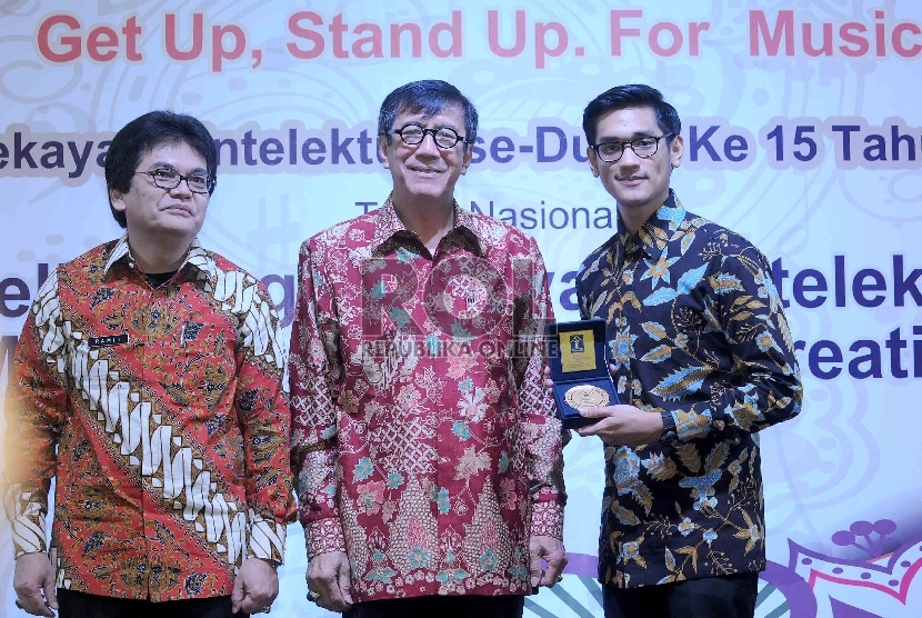 Menteri Hukum dan HAM Yasonna Laoly (tengah) menobatkan musisi Afgan Syah Reza (kanan) menjadi Duta HKI 2015 saat hari Hak Kekayaan Intelektual (HKI) sedunia ke 15 di Kementerian Hukum dan Ham, Jakarta, Kamis (7/5). (Republika/Agung Supriyanto)