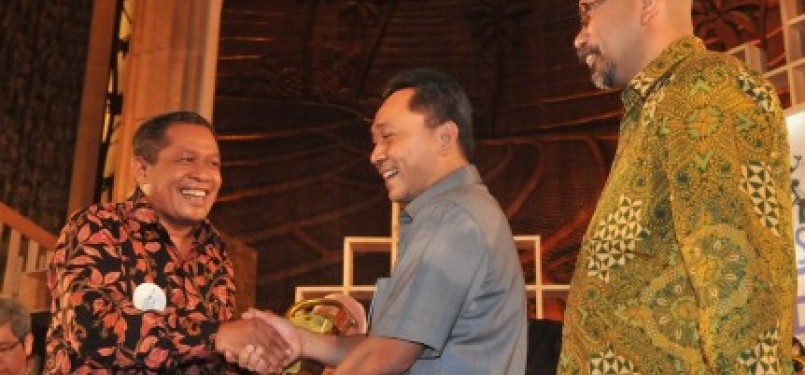 Menteri Kehutanan Zulkifli Hasan (tengah) memberi penghargaan kepada Bupati Wakatobi Hugua (kiri) disaksikan Pendiri La Tofi School of Corporate Social Responsibility (CSR) La Tofi (kanan) dalam Indonesia Green Awards 2011 di Jakarta, Rabu (28/9). 