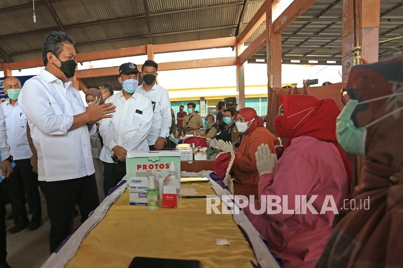 Menteri Kelautan dan Perikanan (KKP) Sakti Wahyu Trenggono (kiri) meninjau pelaksanaan vaksinasi bagi nelayan di tempat pelelangan ikan Misaya Mina, Eretan Wetan, Kandanghaur, Indramayu, Jawa Barat, Senin (9/8/2021). Selain melakukan peninjauan vaksinasi, Menteri KKP juga memberikan bantuan sembako bagi nelayan yang terdampak Pandemi COVID-19.