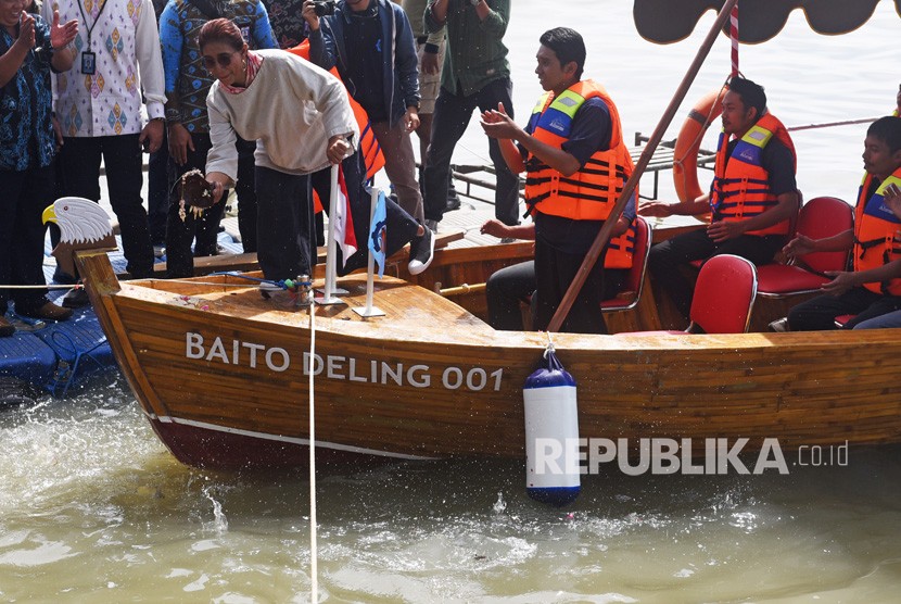 Menteri Kelautan dan Perikanan Susi Pudjiastuti (kiri) memecahkan kendi ketika meluncurkan kapal berbahan bambu laminasi, Baito Deling 001 buatan Institut Teknologi Sepuluh Nopember (ITS) Surabaya di Kenjeran, Surabaya, Senin (2/7).
