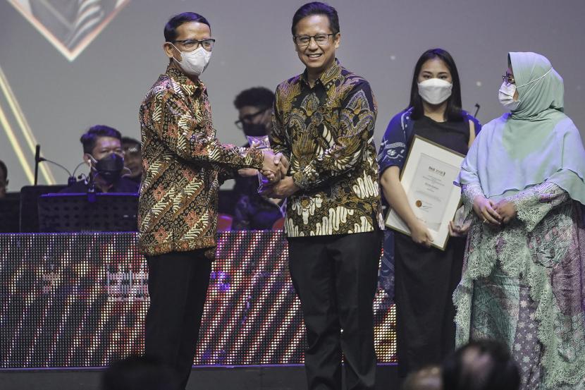 Menteri Kesehatan Budi Gunadi Sadikin (kedua kiri) menyerahkan penghargaan bidang Kedokteran kepada Tonang Dwi Ardyanto (kiri) pada Penghargaan Achmad Bakrie (PAB) XVIII 2022 di Djakarta Theater, Jakarta, Minggu (14/8/2022). PAB tahun ini menghadirkan lima kategori penghargaan dan juga diselenggarakan dalam rangka memperingati HUT RI ke-77 sekaligus HUT ke-80 Kelompok Usaha Bakrie yang mengangkat tema Generasi Bangun Negeri.