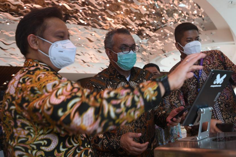 Menteri Kesehatan Budi Gunadi Sadikin (kiri) bersama Dirjen WHO Tedros Adhanom Ghebreyesus (tengah) mencoba portal verifikasi tunggal yang dapat mengecek sertifikat vaksin disela pertemuan pertama G20 Health Ministerial Meeting (HMM) di Sleman, DI Yogyakarta, Senin (20/6/2022). 