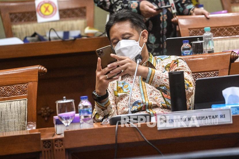 Menteri Kesehatan Budi Gunadi Sadikin melihat ponselnya saat akan mengikuti rapat kerja dengan Komisi IX DPR di Komplek Parlemen, Jakarta.