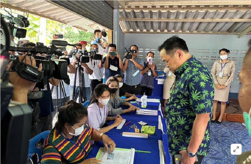 Menteri Kesehatan Thailand Anutin Charnvirakul mengenakan kemeja gelap dengan daun ganja hijau cerah saat mendatangi tempat pemungutan suara pada Ahad (14/5/2023). 