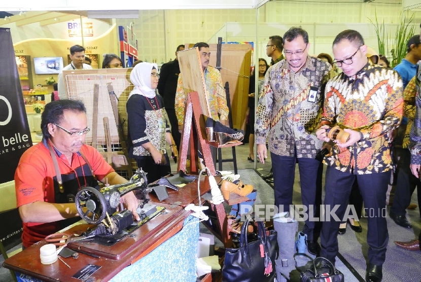 Menteri Ketenagakerjaan, Hanif Dakhiri (kanan), didampingi Direktur Keuangan PT Bhanda Ghara Reksa (Persero) Mohammad Affan (kiri) mengunjungi UMKM binaan BGR yang menyediakan jasa pembuatan sepatu dan tas kulit dalam ajang Indonesia CSR Exhibition 2017 di Jakarta, Jumat (18/8). 