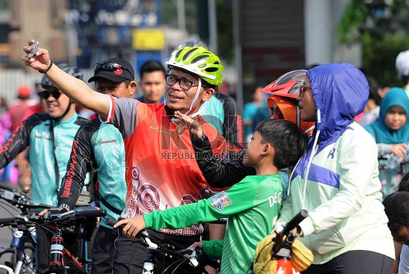  Menteri Ketenagakerjaan Hanif Dhakiri memotret diri sendiri (selfie) dengan warga saat bersepeda di hari Bebas Kendaraan Bermotor di Bundaran HI, Jakarta, Ahad (23/11). 