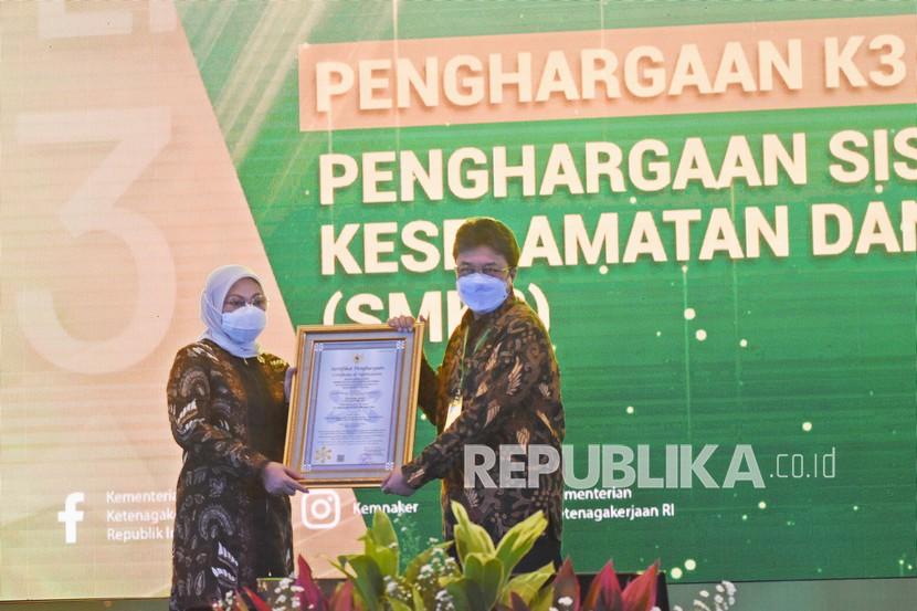 Menteri Ketenagakerjaan Ida Fauziyah (kiri) menyerahkan penghargaan kategori sistem manajemen K3 (SMK3) Terbaik kepada perwakilan dari PT Perusahaan Gas Negara (PGN) Tbk pada acara Penganugerahan Penghargaan Keselamatan dan Kesehatan Kerja (K3) tahun 2021 di Jakarta, Rabu (28/4/2021). Kementerian Ketenagakerjaan memberikan penghargaan pembina K3 terbaik kepada 16 gubernur, penghargaan kecelakaan nihil (zero accident) kepada 1.342 perusahaan, penghargaan program P2HIV-AIDS sebanyak 191 perusahaan, penghargaan sistem manajemen K3 (SMK3) kepada 1.616 perusahaan, dan penghargaan pencegahan dan penanggulangan COVID-19 (P2 Covid-19) kepada 512 perusahaan. 