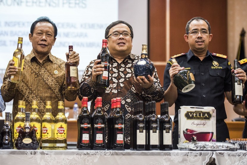 Menteri Keuangan Bambang Brodjonegoro (tengah), Kepala BIN Sutiyoso (kiri) dan Dirjen Bea dan Cukai Heru Pambudi (kanan) menunjukkan barang bukti penyelundupan miras ilegal di kantor Pusat Bea dan Cukai, Jakarta, Rabu (27/1).