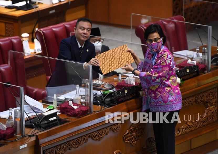 Menteri Keuangan Sri Mulyani (kanan) menyerahkan tanggapan pemerintah kepada Wakil Ketua DPR Sufmi Dasco Ahmad (kiri) dalam Rapat Paripurna pengesahan UU Pertanggungjawaban atas Pelaksanaan (P2) Anggaran Pendapatan dan Belanja Negara (APBN) Tahun Anggaran 2020 di Kompleks Parlemen, Senayan, Jakarta, Selasa (7/9/2021). DPR secara resmi mengesahkan RUU P2 APBN 2020 menjadi undang-undang.