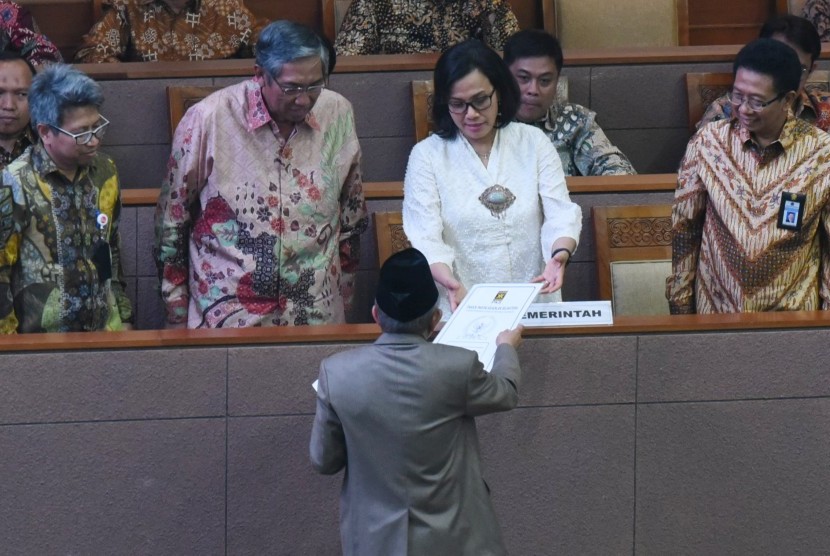 Menteri Keuangan Sri Mulyani (kedua kanan) didampingi Wakil Menteri Keuangan Mardiasmo (kedua kiri) menerima pandangan fraksi atas pertanggungjawaban pelaksanaan APBN 2017 dari anggota DPR fraksi PKS Refrizal (tengah) saat Rapat Paripurna di Kompleks Parlemen Senayan, Jakarta, Selasa (10/7).