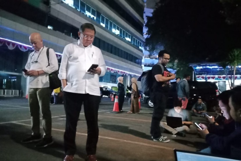 Menteri Komunikasi dan Informatika Rudiantara keluar dari gedung usai merasakan gempa, di Jakarta, Jumat (2/8). Pihaknya mengimbau agar ada running text gempa waspada tsunami. 