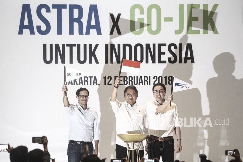 Menteri Komunikasi dan Informatika Rudiantara (tengah) mengangkat bendera bersama Presiden Direktur PT Astra International Tbk Prijono Sugiarto (kanan) dan CEO & CO-Founder GO-JEK Nadiem Makariem (kiri) seusai penandatanganan kerja sama Investasi antara Astra Internasional dengan GO-JEK di Jakarta, Senin (12/2).