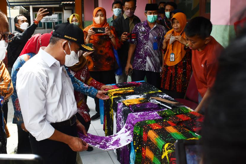  Menko PMK Muhadjir Effendy (kiri) mengamati kain batik hasil karya siswa Sekolah Luar Biasa Negeri Karangrejo di Magetan, Jatim. 