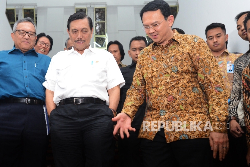 Menteri Koordinator Bidang Kemaritiman Luhut Binsar Pandjaitan  bersama Gubernur Provinsi DKI Jakarta Basuki Tjahaja Purnama (ketiga kanan) berjalan menuruni anak tangga untuk memberikan keterangan kepada awak media seusai melakukan pertemuan tertutup di K