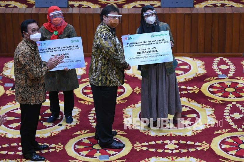 Menteri Koordinator Bidang Perekonomian Airlangga Hartarto (kedua kanan) didampingi Direktur Hubungan Kelembagaan BNI Sis Apik Wijayanto (kiri) menyerahkan secara simbolis Kredit Usaha Rakyat (KUR) kepada mitra platfom digital di Jakarta, Rabu (23/9). Pemerintah menggandeng platfom digital untuk memperluas penyaluran KUR kepada UMKM yang berperan dalam mendorong pemulihan ekonomi nasional dan penyerapan tenaga kerja pada masa pandemi COVID-19, salah satunya dengan menghadirkan aplikasi BNI Move untuk mempermudah akses kredit bagi seluruh UMKM.