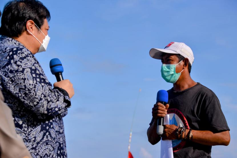 Menteri Koordinator Bidang Perekonomian Airlangga Hartarto (kiri) saat berbincang dengan seorang nelayan di sela pemberian Bantuan Tunai Pedagang Kaki Lima (PKL), Warung, dan Nelayan (BT-PKLWN) di Kampung Ujung Labuan Bajo, Manggarai Barat, NTT, Senin (14/3/2022).