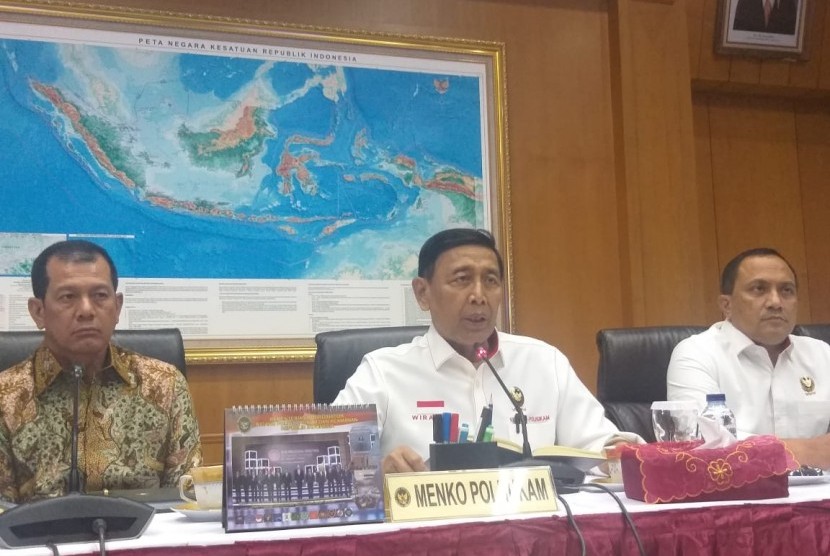 Menteri Koordinator Politik Hukum dan Keamanan Wiranto (tengah) memberikan keterangan pers di Gedung Kemenkopolhukam, Jakarta Pusat, Rabu (21/8).