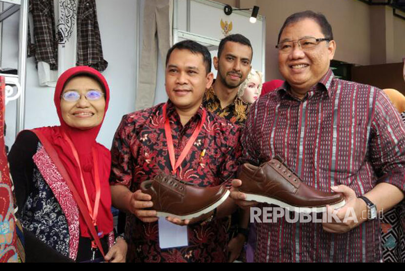 Menteri Koperasi dan UMKM Anak Agung Gede Ngurah Puspayoga memamerkan sepatu hasil produksi pengusaha lokal dalam acara Temu Usaha Wirausaha Pemula, di Hotel Ibis Cawang, Jakarta, Kamis (6/4).