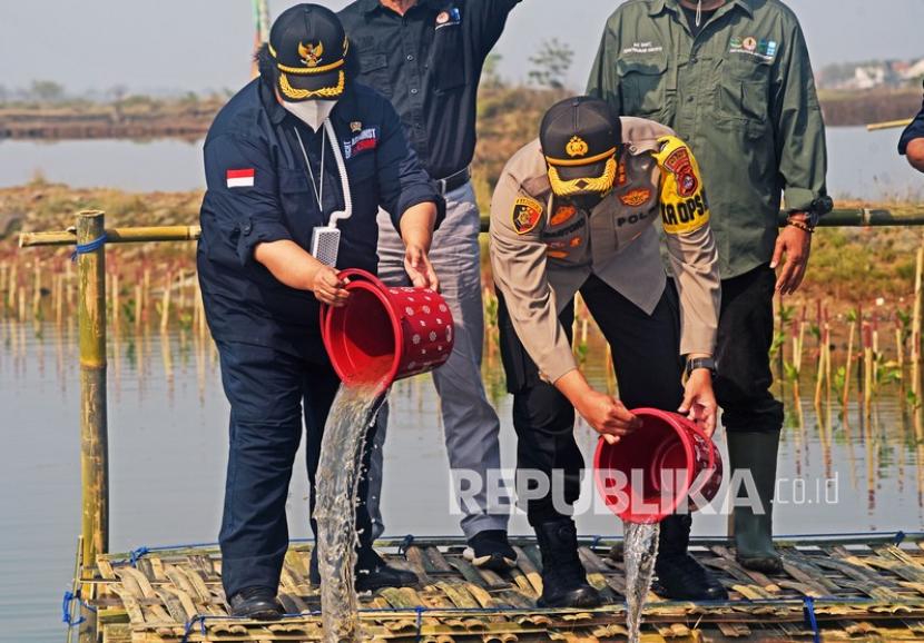 Menteri Lingkungan Hidup dan Kehutanan Siti Nurbaya (kiri) didampingi Kapolres Serang AKBP Mariyono (kanan) menuangkan air saat acara Penaman Mangrove Padat Karya di perairan Teluk Banten, Lontar, Serang, Sabtu (7/11/2020). Program padat karya untuk mengijaukan kembali 15 ribu hektar hutan mangrove yang melibatkan 30 ribu orang di 34 provinsi dengan biaya Rp406 miliar itu dimaksudkan untuk mempercepat pemulihan ekonomi nasional dampak COVID-19 sekaligus untuk memulihkan kelestarian hutan mangrove di Indonesia. 