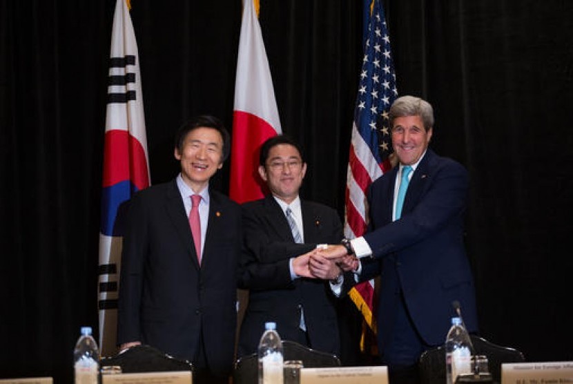 Menteri Luar Negeri Korea Selatan Yun Byung Se (kiri), Menteri Luar Negeri Jepang Fumio Kishida dan Menteri Luar Negeri AS John Kerry bersalaman dalam pertemuan tiga pemimpin di New York, Ahad (18/9).