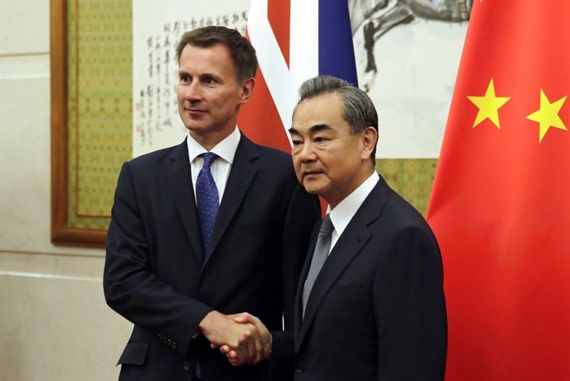  Menteri Luar Negeri (Menlu) Inggris Jeremy Hunt (kiri) berjabat tangan dengan Menlu Cina Wang Yi ketika mereka berpose untuk foto sebelum pertemuan mereka di Wisma Negara Diaoyutai di Beijing, Senin, 30 Juli 2018.