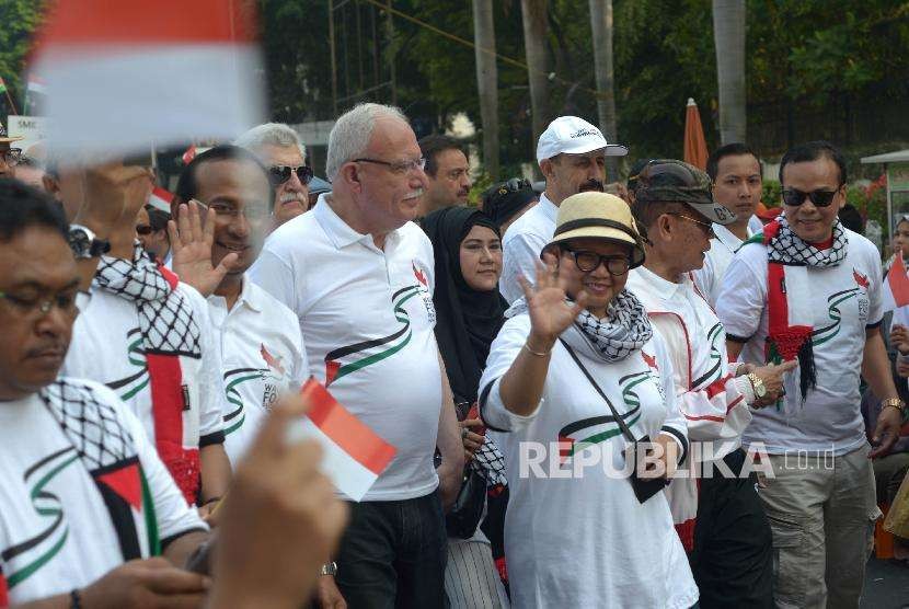 Menteri Luar Negeri (Menlu) RI Retno Marsudi (kedua kanan) dan Menlu Palestina Riyad al-Maliki (tengah)jalan santai bersama dalam acara Walk for Peace and Humanity di kawasan car free day (CFD) Jakarta, Ahad (14/10).