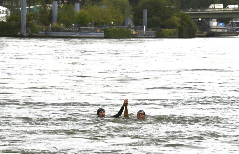 Menteri OR Prancis Amelie Oudea-Castera (kiri) berenang di Sungai Seine, Paris, Sabtu (13/7/2024). 