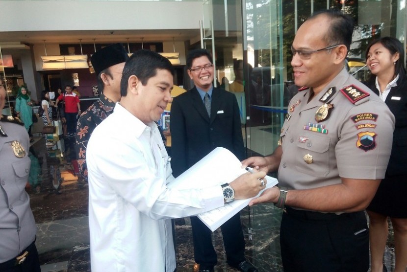  Menteri PANRB Yuddy Chrisnadi didampingi Kapolres Banyumas Gidion Arif Setiawan menyimak aplikasi online untuk perpanjangan SIM dan SKCK di Mapolres Banyumas, Rabu (22/6).