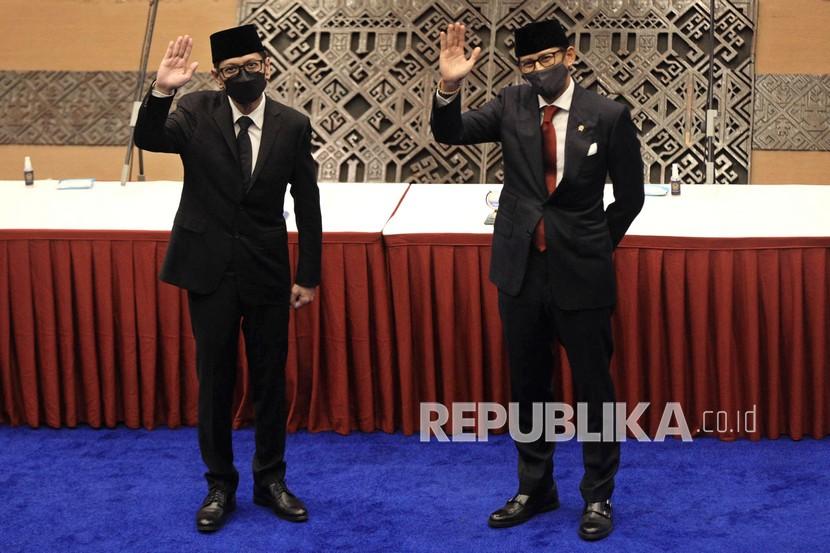 Menteri Pariwisata dan Ekonomi Kreatif (Menparekraf) Sandiaga Salahuddin Uno (kanan) bersama mantan Menparekraf Wishnutama Kusubandio (kiri) melambaikan tangan usai upacara serah terima jabatan (Sertijab) di Jakarta, Rabu (23/12/2020). Sandiaga merupakan satu dari enam menteri baru yang dilantik Presiden Joko Widodo untuk menggantikan posisi menteri lama (