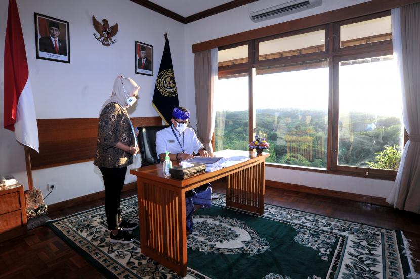 Menteri Pariwisata dan Ekonomi Kreatif (Menparekraf) Sandiaga Salahuddin Uno (kanan) bekerja di ruangannya di Politeknik Pariwisata Bali, Nusa Dua, Badung, Bali, Kamis (27/5/2021). Menparekraf Sandiaga Uno bersama jajarannya melakukan 