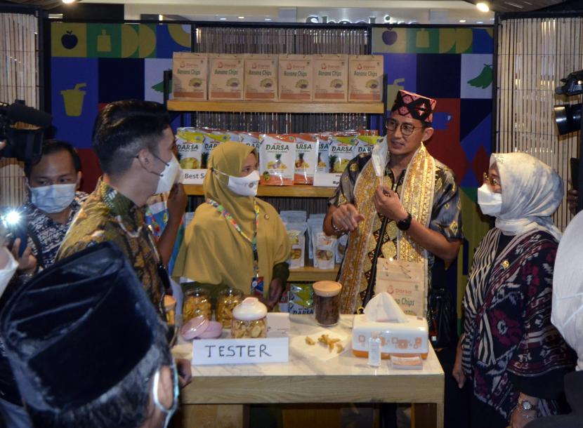 Menteri Pariwisata dan Ekonomi Kreatif (Menparekraf) Sandiaga Salahuddin Uno (kedua kanan) mengamati produk industri kreatif yang dijual pada Pameran Apresiasi Kreasi Indonesia 2021 di Bandar Lampung, Lampung, Sabtu (23/10).