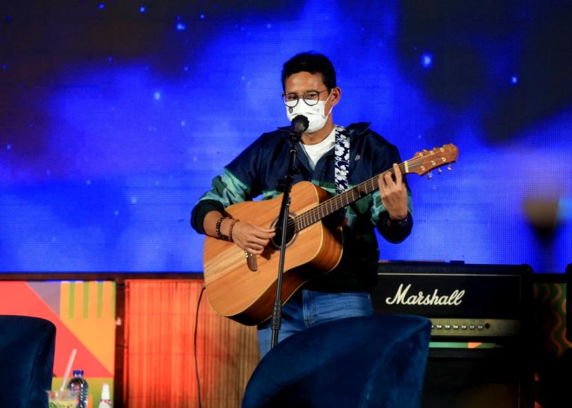 Menteri Pariwisata dan Ekonomi Kreatif (Menparekraf) Sandiaga Salahuddin Uno, unjuk kebolehan bermain gitar dalam rangkaian acara Puncak Apresiasi Kreasi Indonesia (AKI) 2021 di Gandaria City, Jakarta Selatan, Jumat (10/12/2021) malam. 