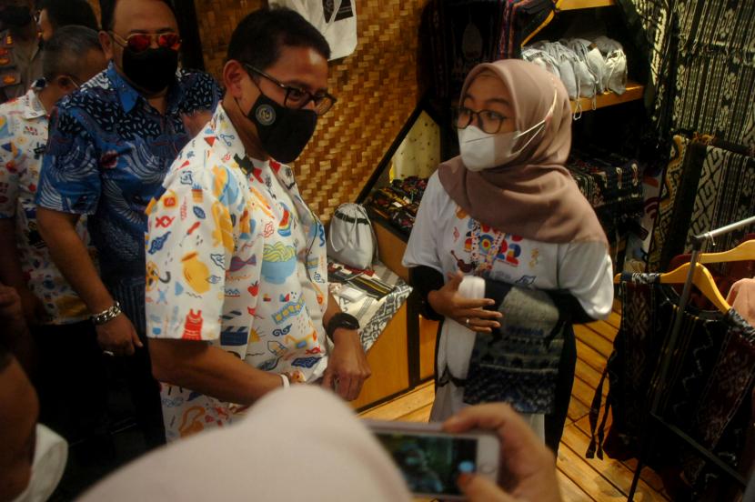 Menteri Pariwisata dan Ekonomi Kreatif (Menparekraf) Sandiaga Salahuddin Uno (kedua kiri) didampingi Wali Kota Tegal Dedy Yon Supriyono (kiri) berbincang dengan pelaku UMKM saat kunjungan ke pameran Apresiasi Kreasi Indonesia (AKI) 2022 di salah satu mall Tegal, Jawa Tengah, Ahad (3/7/2022). Menteri Pariwisata dan Ekonomi Kreatif (Menparekraf) Sandiaga Uno menyatakan sarana promosi melalui digitalisasi menjadi bagian penting dari 27 pelaku ekonomi kreatif di Tegal, Jawa Tengah, yang berpartisipasi dalam Apresiasi Kreasi Indonesia (AKI) 2022.